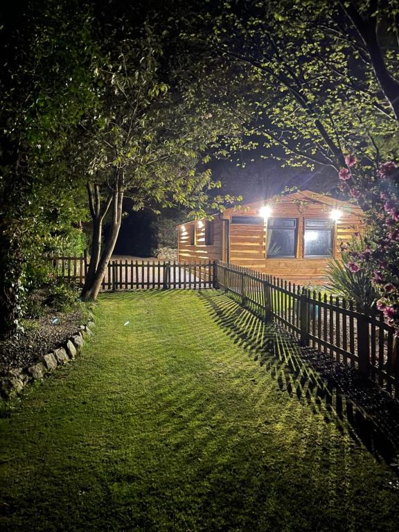 卡纳芬Snowdonia cabin的夜间在院子里的小屋,带栅栏