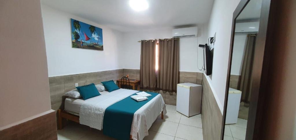 阿拉卡茹阿瓜多拉达斯旅馆的一间卧室配有一张带蓝色枕头的床