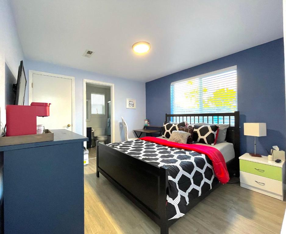 旧金山Golden Gate Park Suite的一间卧室设有黑色和白色的床和蓝色的墙壁。
