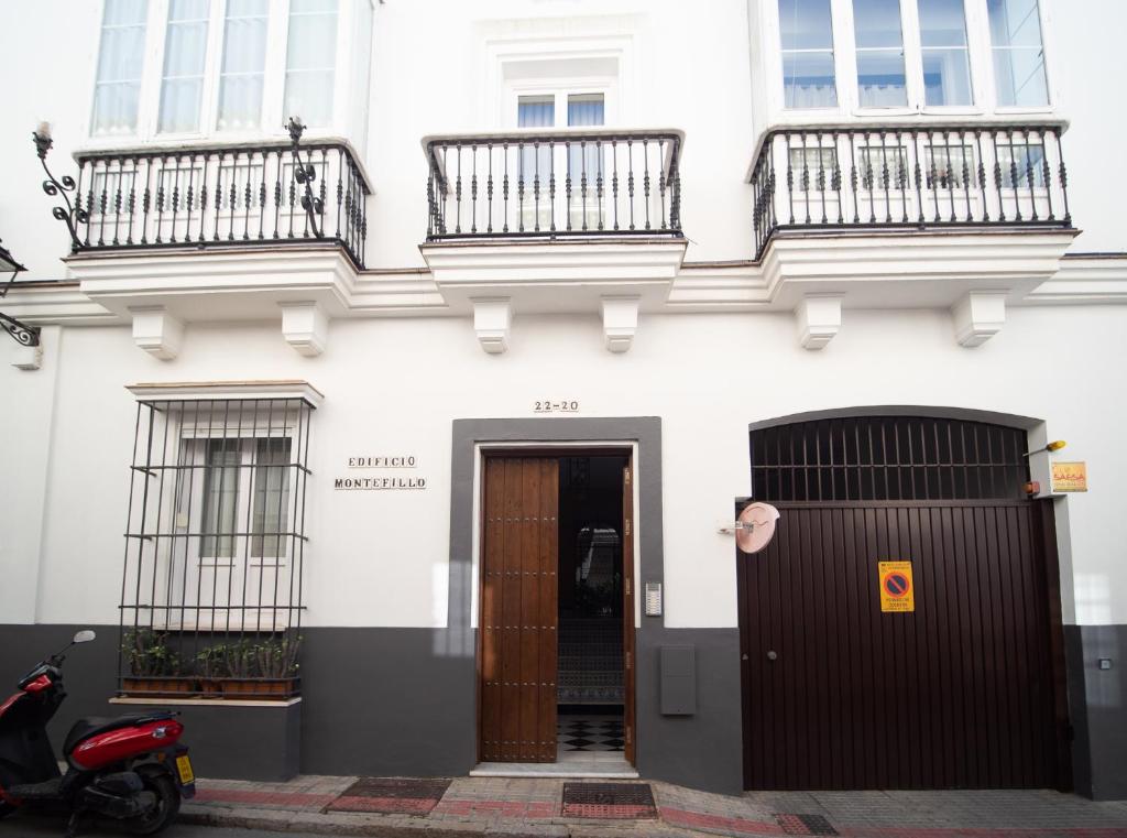 桑卢卡尔-德巴拉梅达Apartamento Montefillo的白色的建筑,设有两个阳台和门
