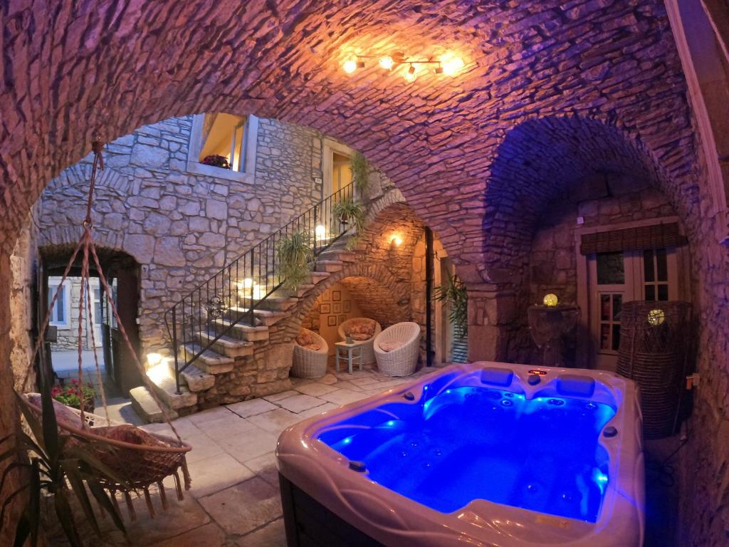 布拉托Stone House Hedonia的石头建筑中带蓝色浴缸的大浴室