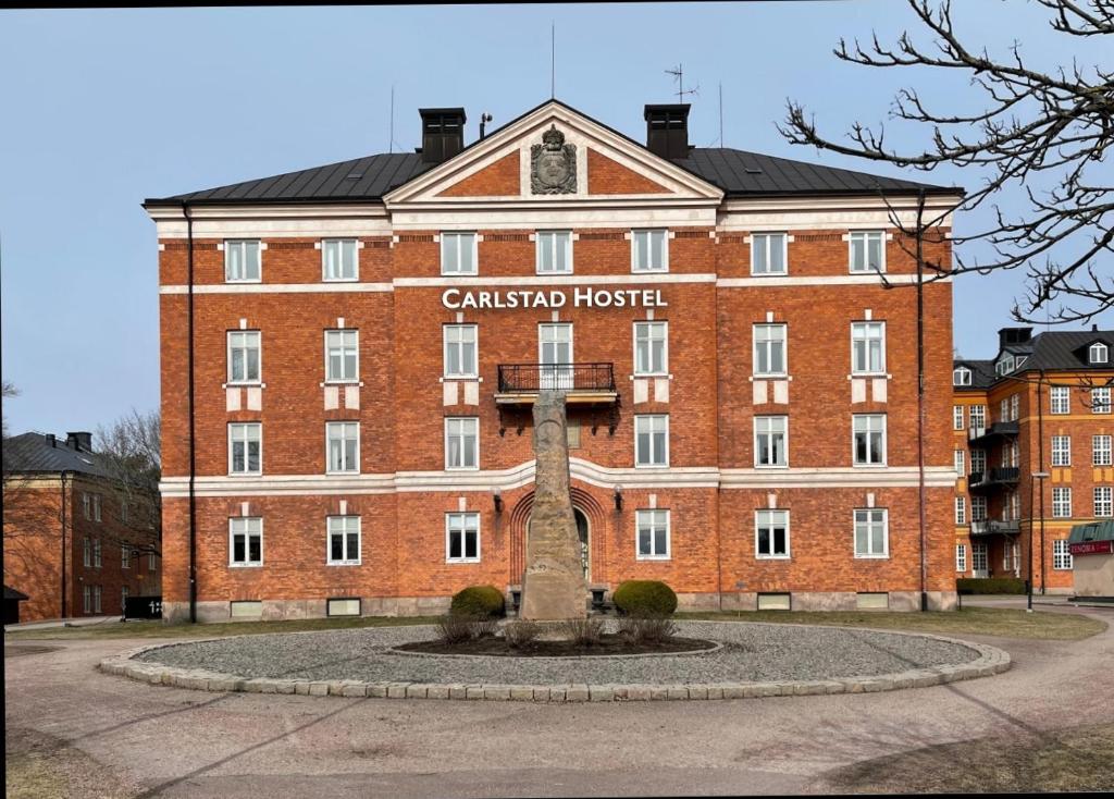 卡尔斯塔德Carlstad Sport Hostel的一座大型红砖建筑,上面有标志