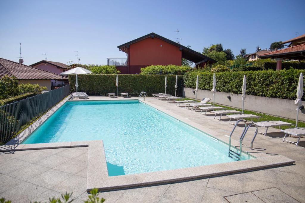 马斯诺维斯康蒂Residenza La Corte Visconti - flat with pool and patio的一个带椅子的大型游泳池