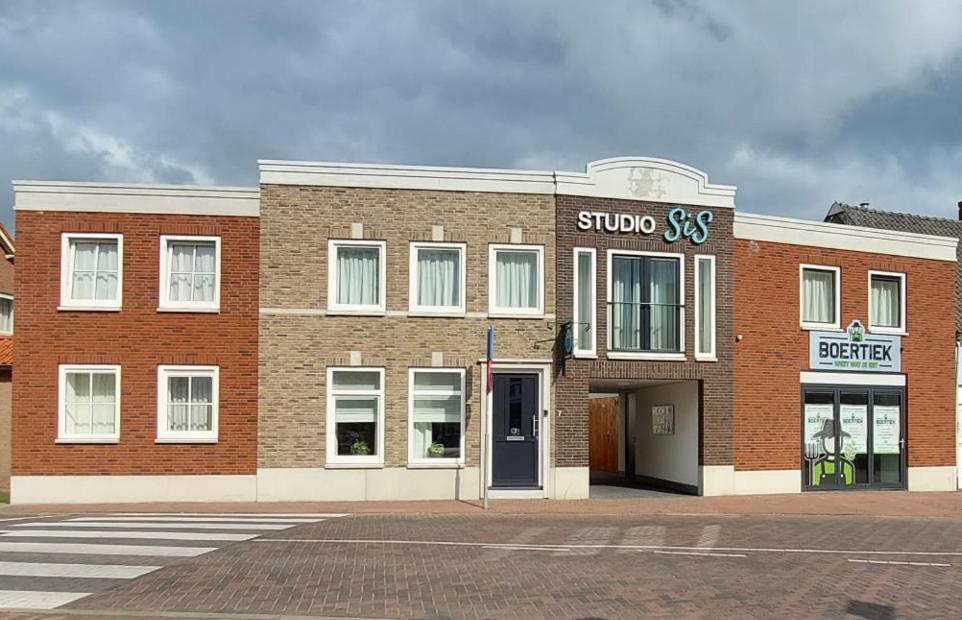 SteenbergenHotel Studio SIS的街上有商店的砖砌建筑