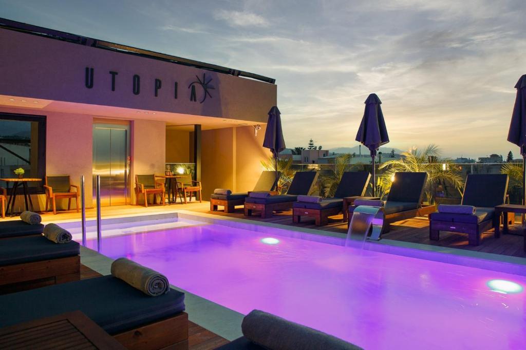 普拉坦斯Utopia Luxury Suites的一座带椅子的大型游泳池和一座建筑