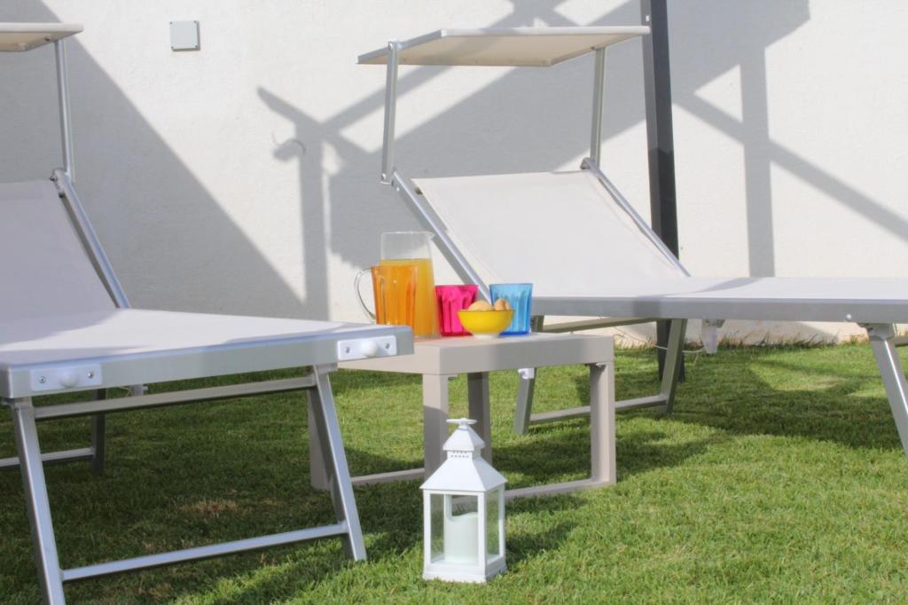 科尔萨诺Appartamento Roberti的草上野餐桌和两把椅子