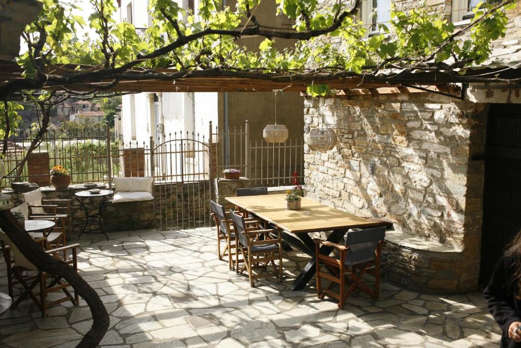 拉夫科斯Ξενώνας Λαύκος的户外庭院配有木桌和椅子