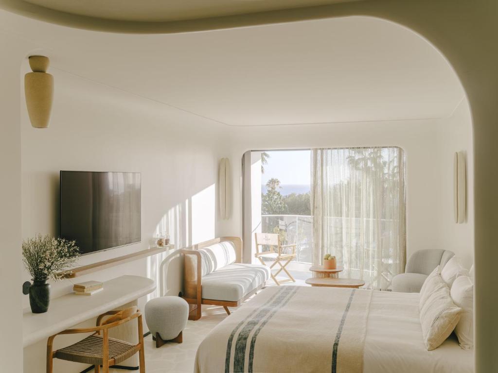 戛纳Hôtel & Spa Belle Plage的白色的卧室设有床和窗户