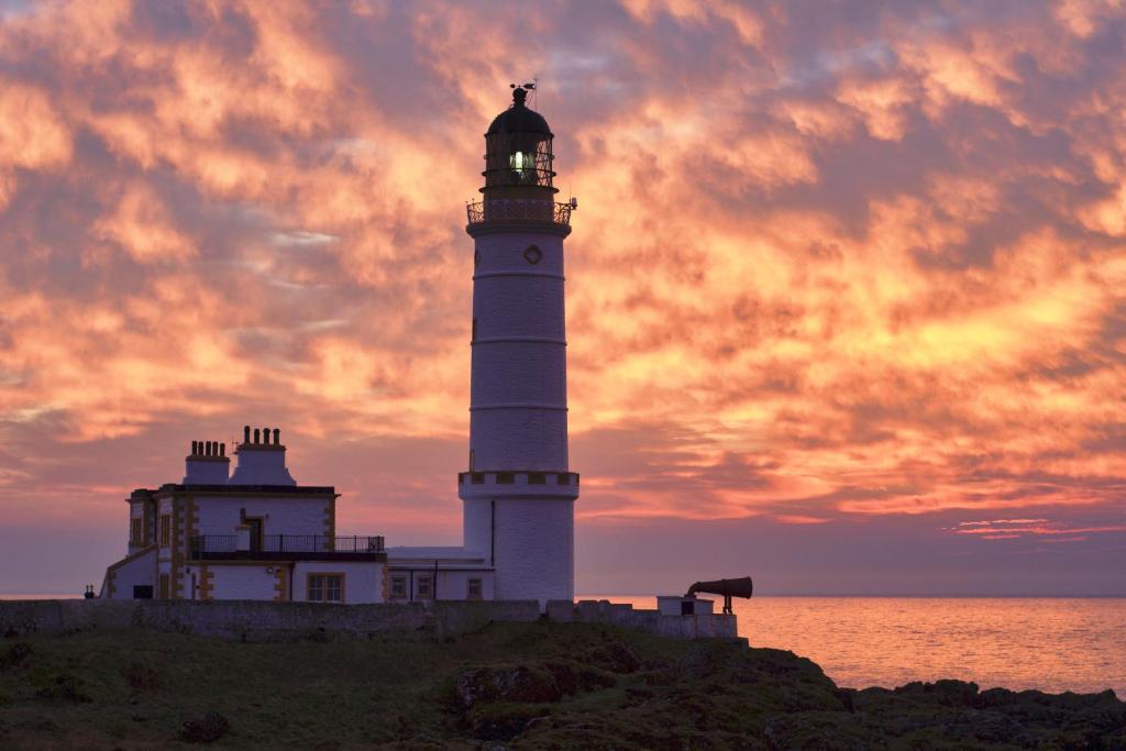 KirkcolmCorsewall Lighthouse Hotel的一座灯塔,位于海边的山顶上