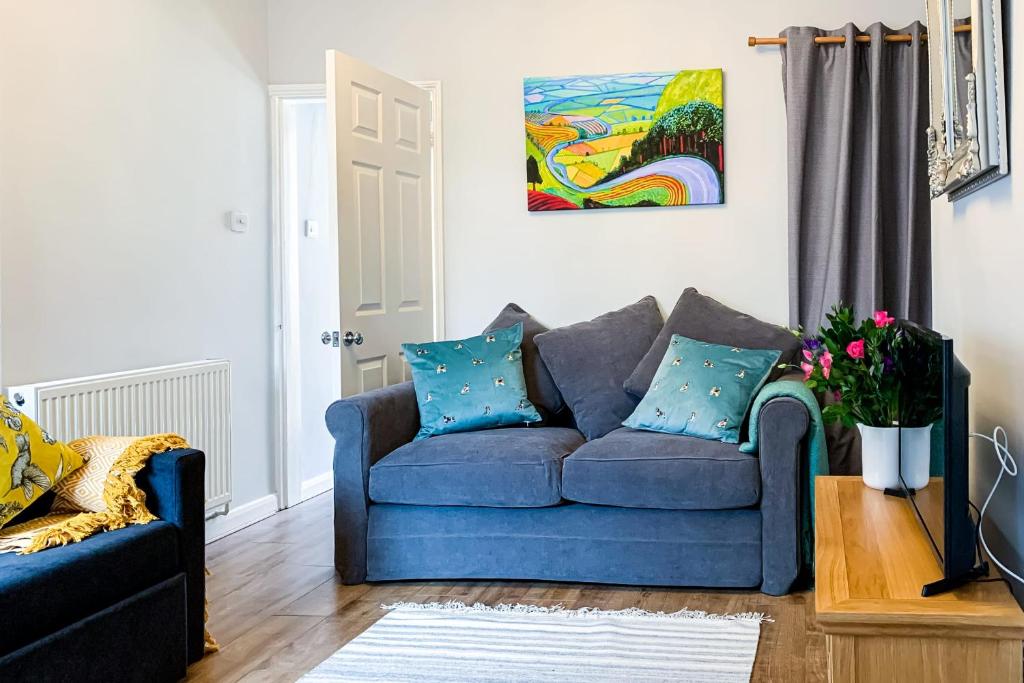 约克The Knavesmire - Quaint Victorian Home With Free Parking的客厅配有蓝色沙发和绘画作品