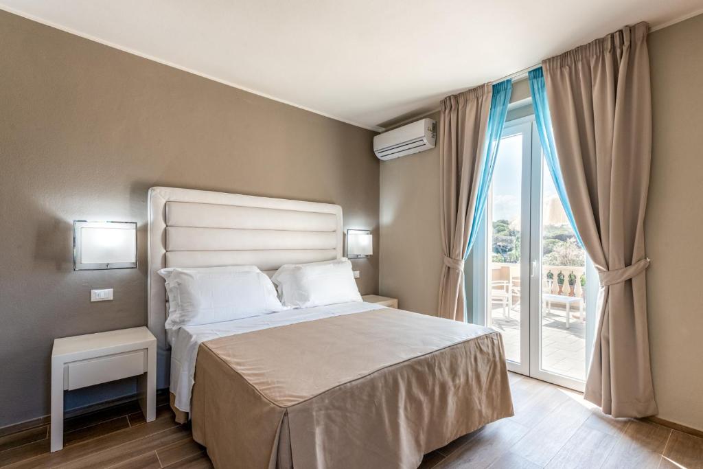 马里纳-迪卡斯塔涅托Hotel Villa Bolgheri的一间卧室设有一张床和一个大窗户
