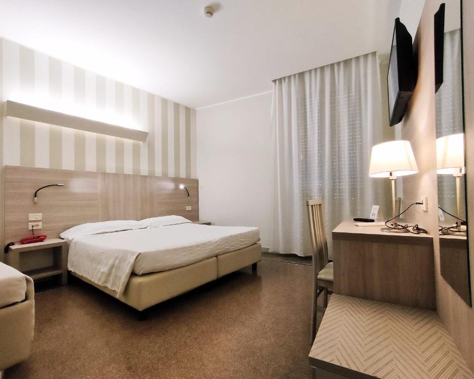 热那亚维托瑞亚酒店的配有一张床和一张书桌的酒店客房