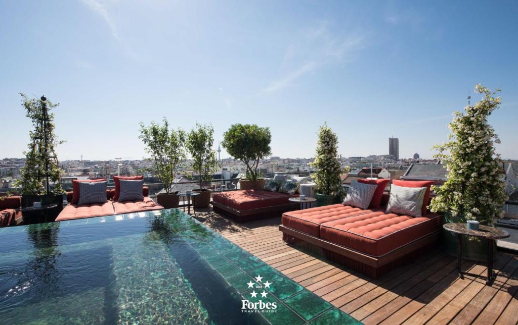 马德里BLESS Hotel Madrid - The Leading Hotels of the World的一个带沙发和游泳池的屋顶露台
