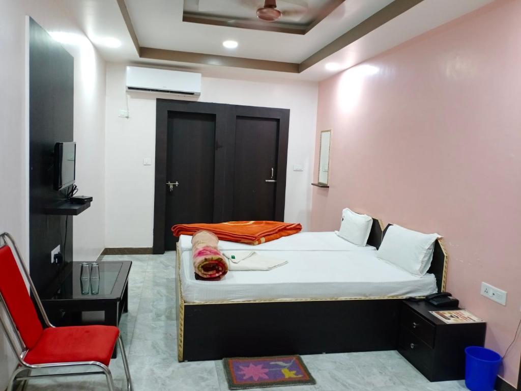 加雅Hotel Sunaina International的一间卧室配有一张床和一张红色椅子