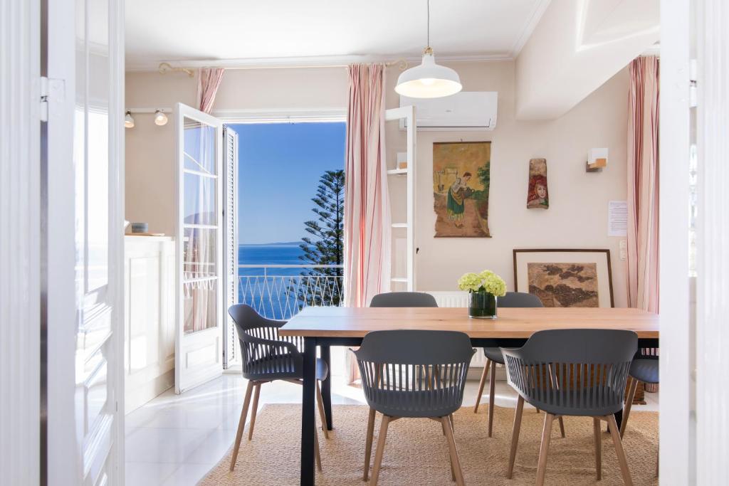 科孚镇Corfu town tranquility gem的一间带桌椅和大窗户的用餐室