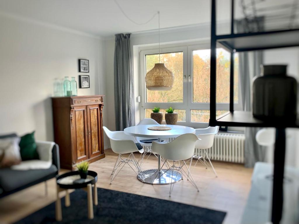 萨尔路易斯Angie´s Home的客厅配有桌子和白色椅子