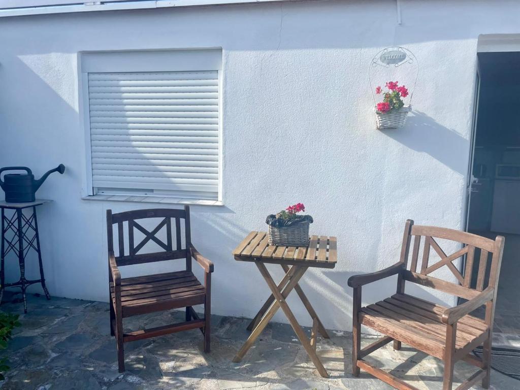 圣米格尔德阿沃纳Casa rosa的庭院里设有两把椅子和一张带鲜花的桌子