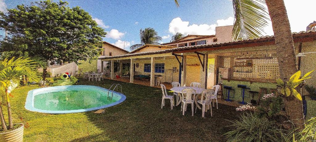 帕纳米林Qavi - Casa com piscina na Praia de Cotovelo的一座带游泳池和桌椅的房子