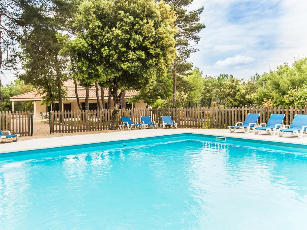 Labastide-de-ViracVilla La Lauze的一个带蓝色椅子和围栏的游泳池