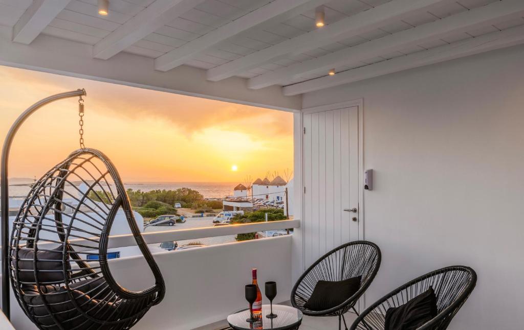 米克诺斯城Sunset Windmills Suites的客房设有两把椅子和一扇海景窗户。
