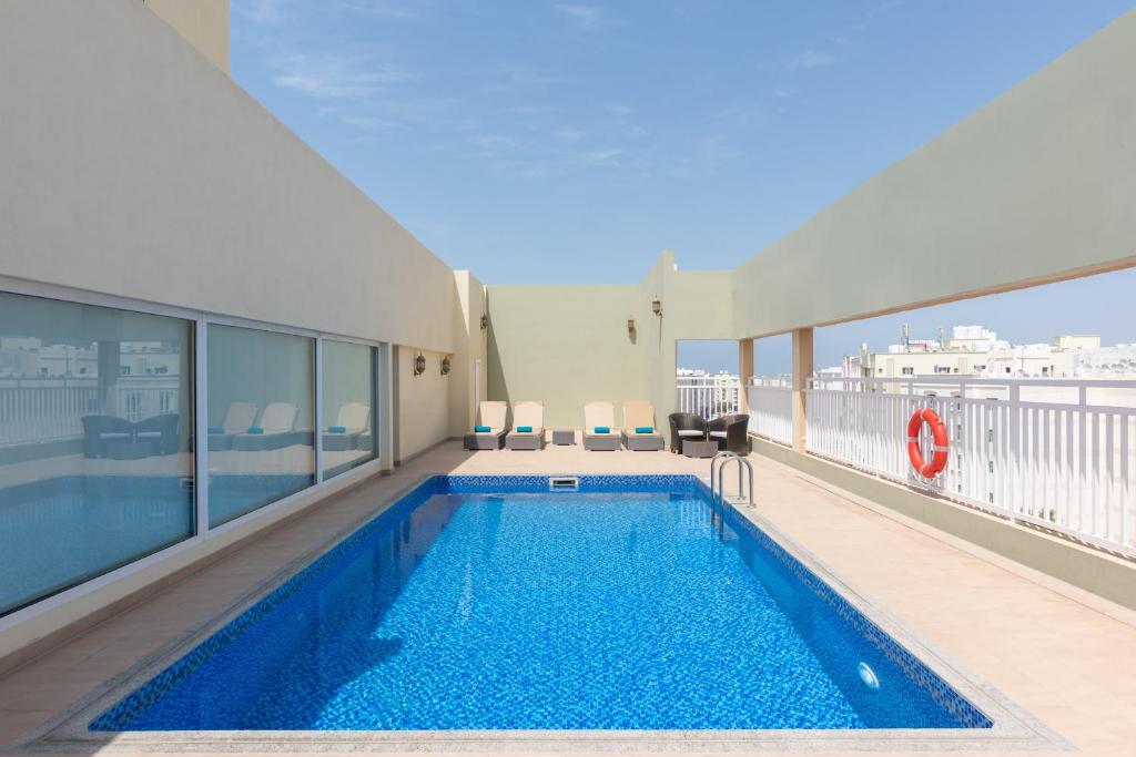 马斯喀特Centara Life Muscat Dunes Hotel的大楼上层的游泳池