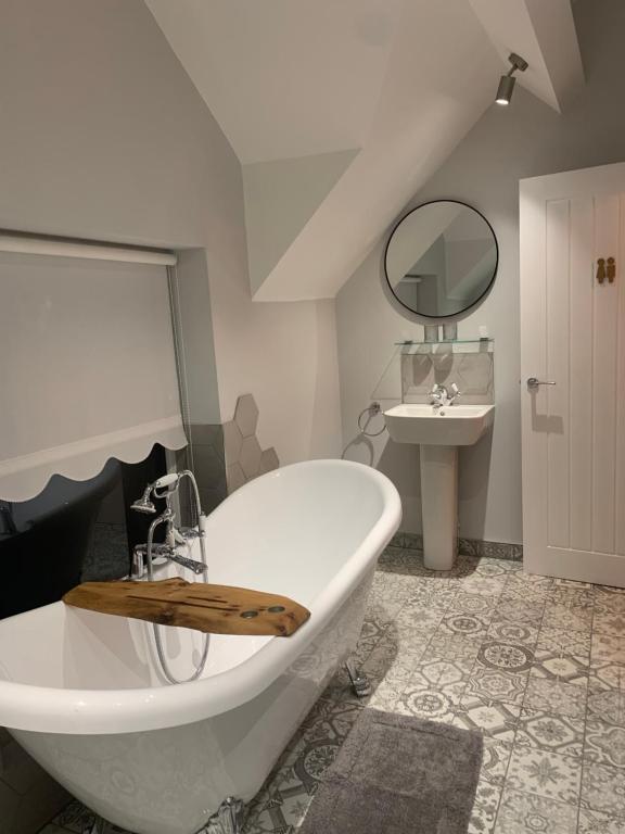 ConisbroughMinneymoor lodge的浴室配有大型白色浴缸和水槽