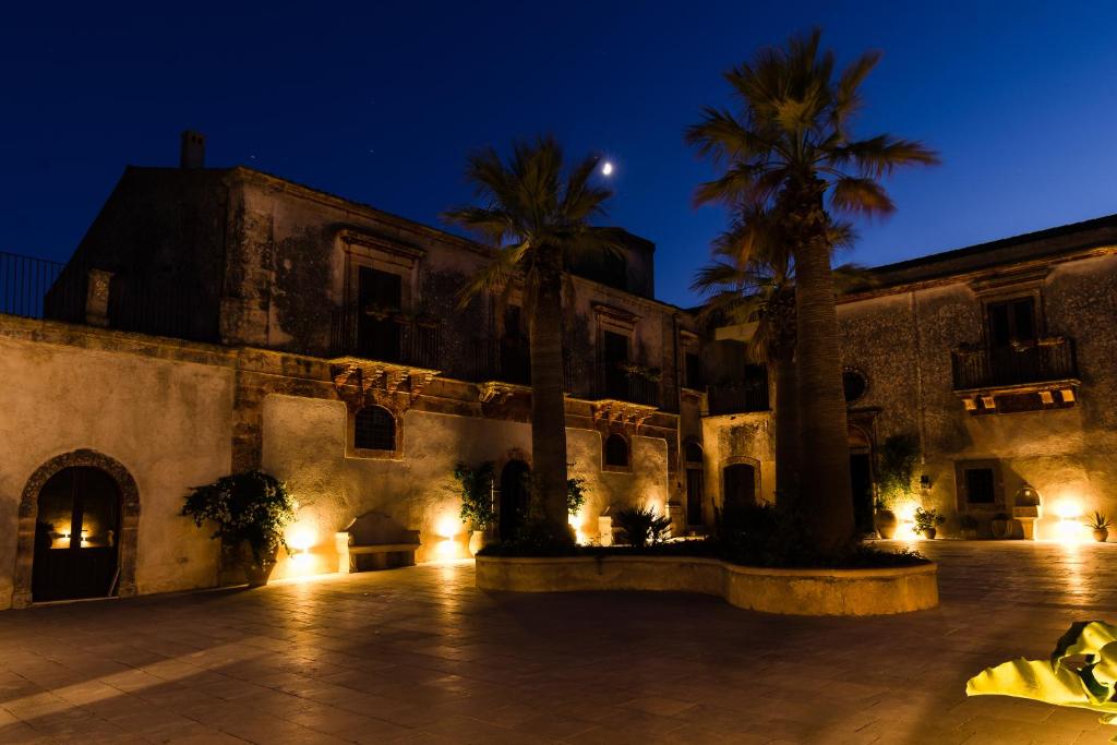 索拉里诺Borgo del Carato的一座棕榈树和灯光的建筑