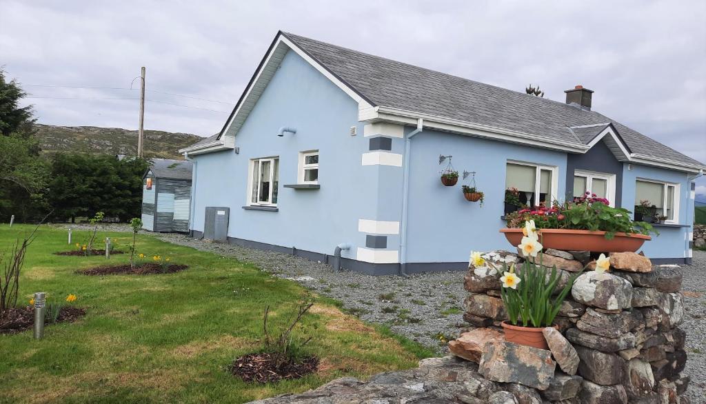 克利夫登Clifden Wildflower Cottage - Clifden Countryside Lettings的前面有石墙的蓝色房子