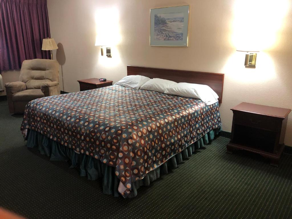 MarysvilleMarysville Surf Motel的配有一张床和一把椅子的酒店客房