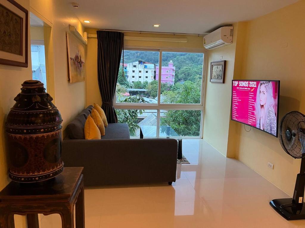 芭东海滩3bedrooms2baths Near Patong Beach 10 Km Away的带沙发和大窗户的客厅