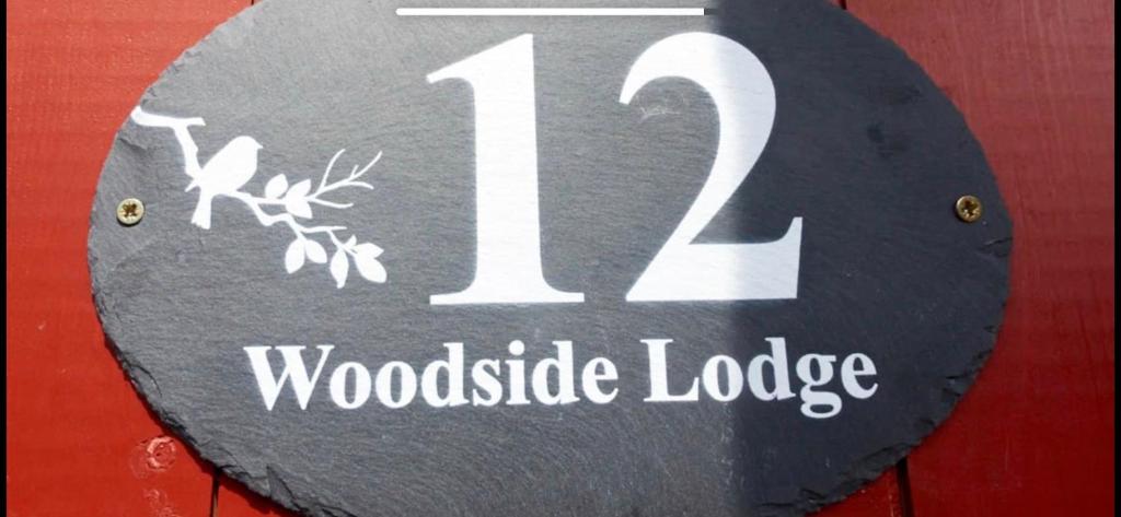 ThurstastonWoodside Lodge的林荫小屋号标志