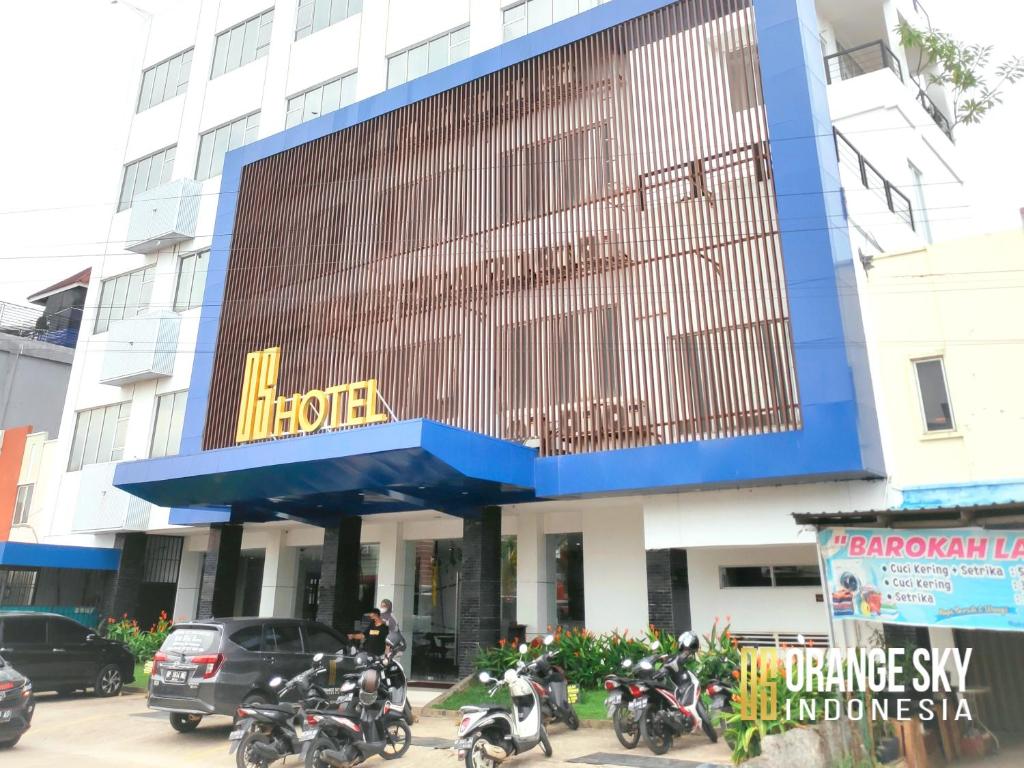 巴淡岛中心OS Hotel Airport Batam的停在大楼前的一组摩托车