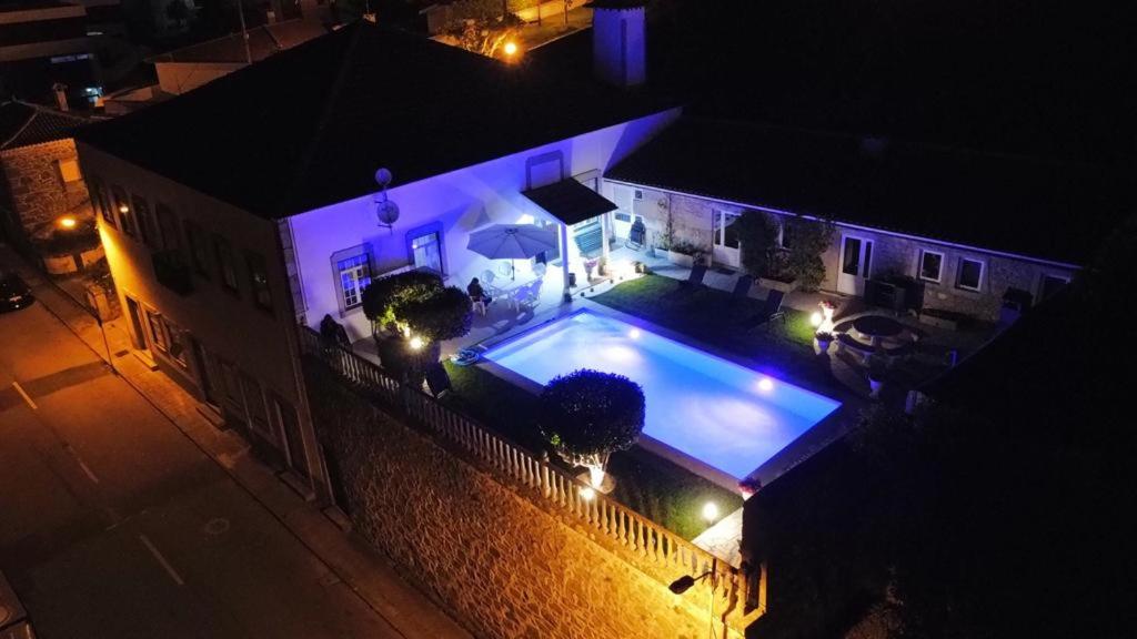 维亚纳堡Casa do Adro的享有房子顶部的景色,晚上设有游泳池