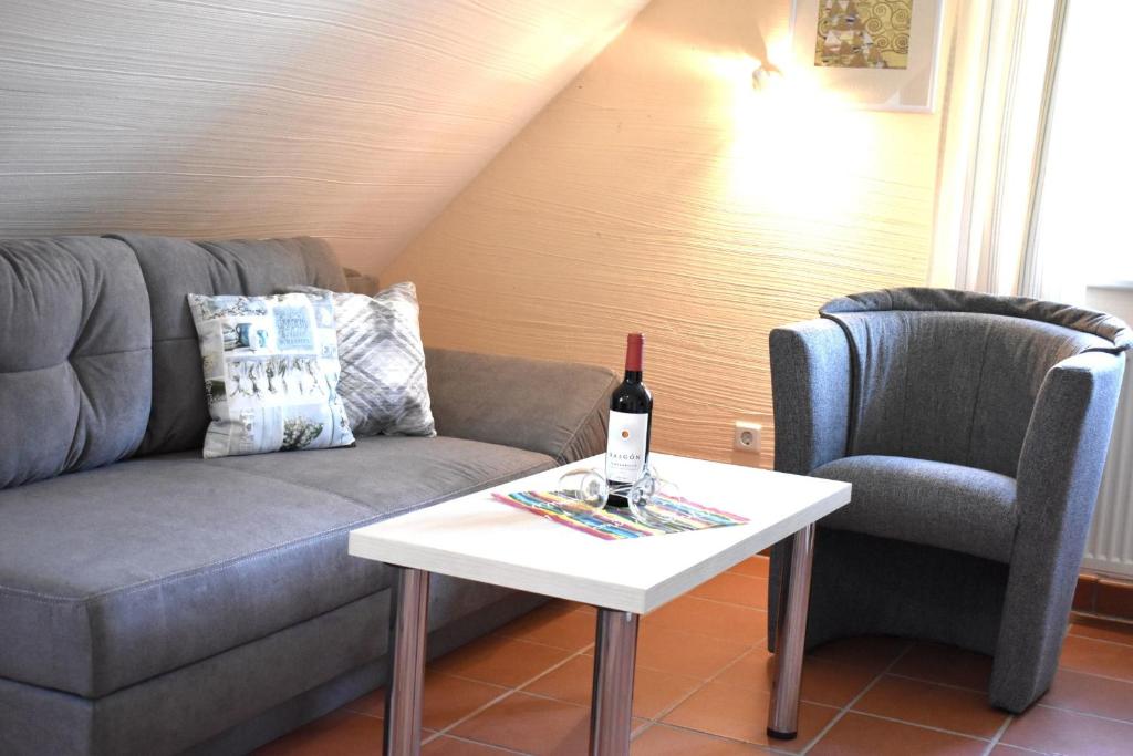 KreptitzFerienparadies Rugana B48的客厅配有沙发和一张桌子及一瓶葡萄酒