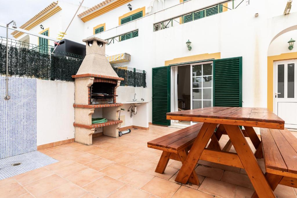 曼塔罗塔Villa Oriente by ALGARVEMANTA的一个带木桌和比萨饼烤箱的庭院