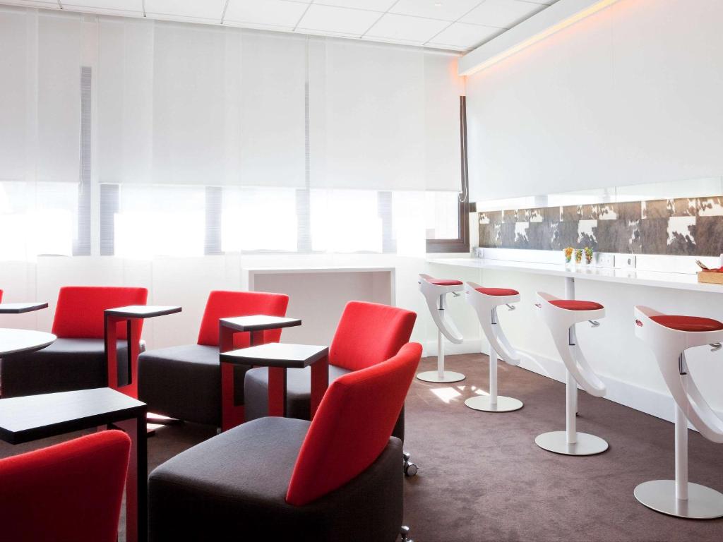 马赛诺沃特马赛老港口酒店的一间设有红色椅子的等候室和一间酒吧