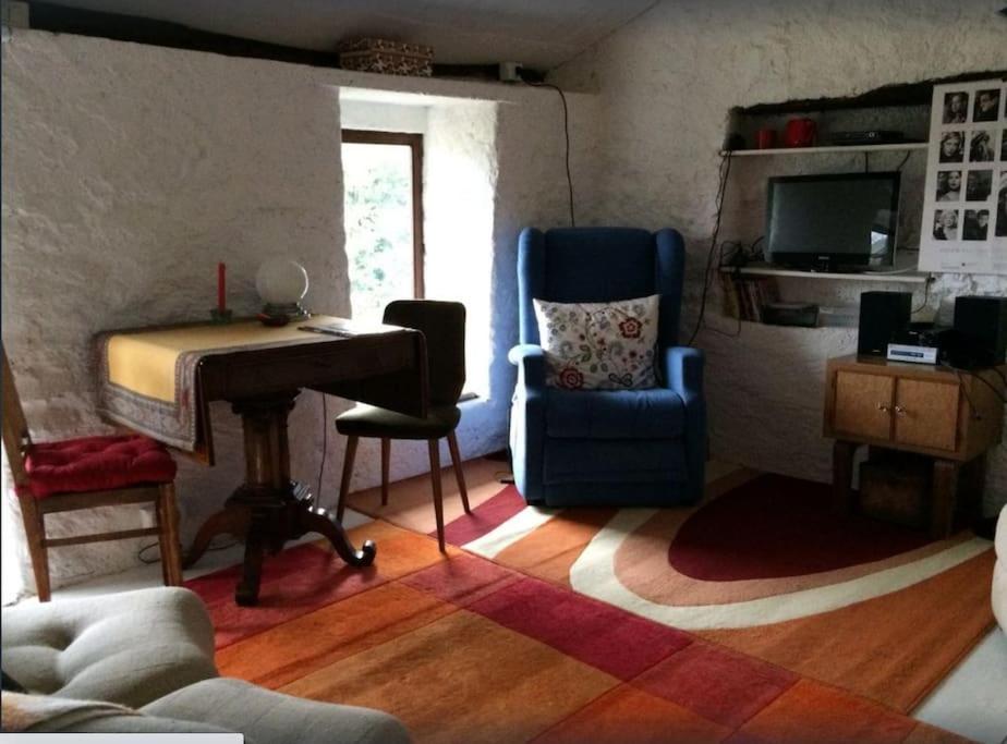 CaravateCountry house的客厅配有钢琴、椅子和书桌