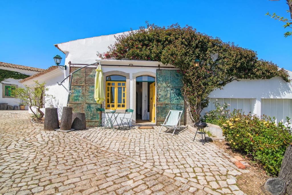 圣巴巴拉-迪内希Algarve Charming Rural 1br Villa的白色的房子,设有黄色的门和庭院