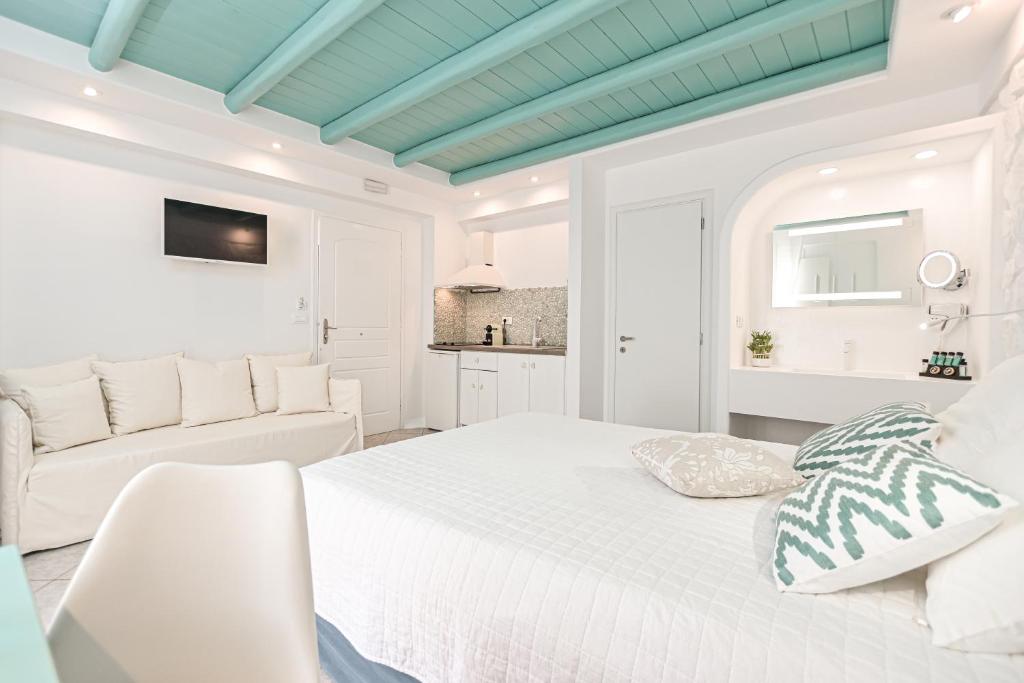纳克索乔拉Naxos Evilion Luxury Apartments & Suites的白色卧室配有床和沙发