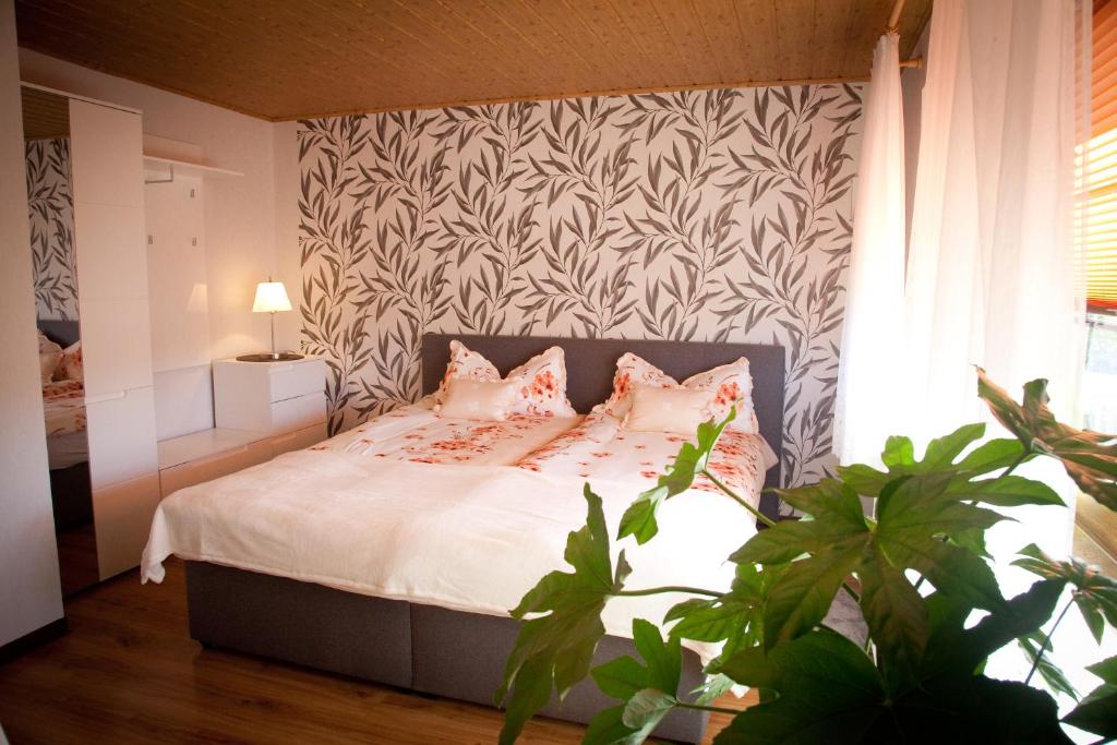 ThumGästezimmer im Grünen Haus的一间卧室配有带白色床单和粉红色枕头的床。