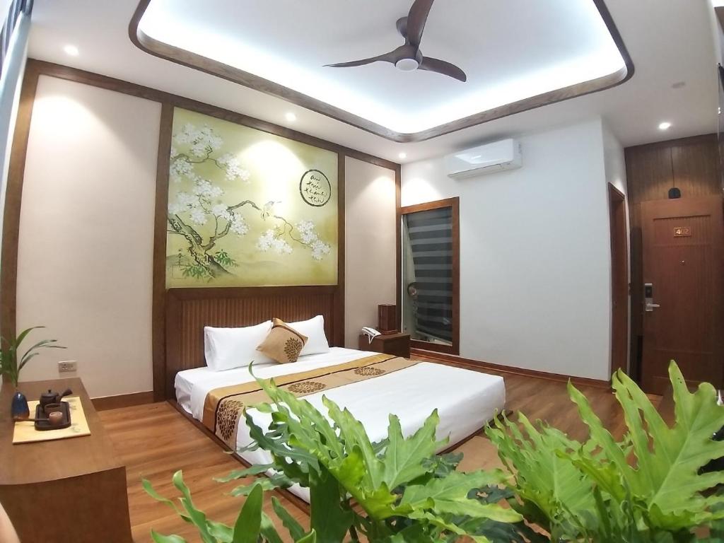 下龙湾Samatha Hotel Bai Chay, Ha Long的一间卧室配有一张床和吊扇