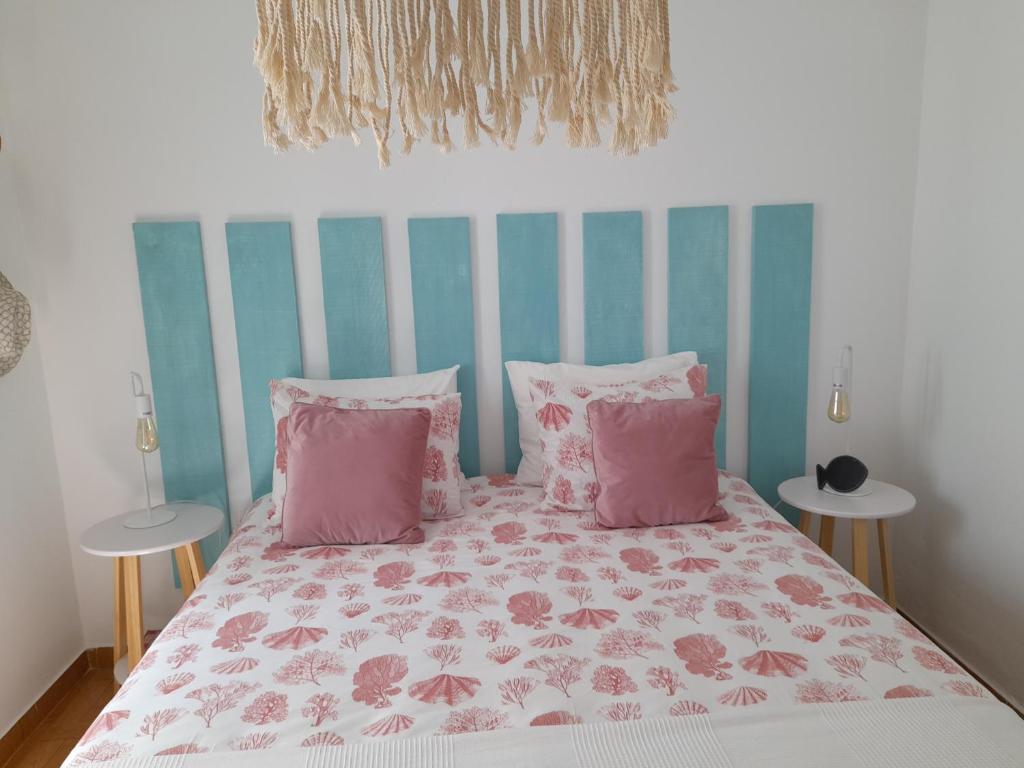 奥德赛克斯Carlo's Beach Guest House的一间卧室配有带粉红色和粉红色枕头的床