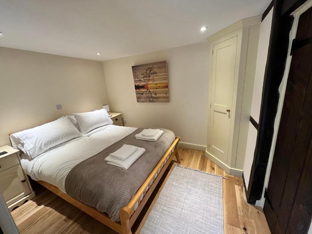 利德尼Swan House Tea Room and Bed & Breakfast的一间卧室配有一张床,上面有两条毛巾
