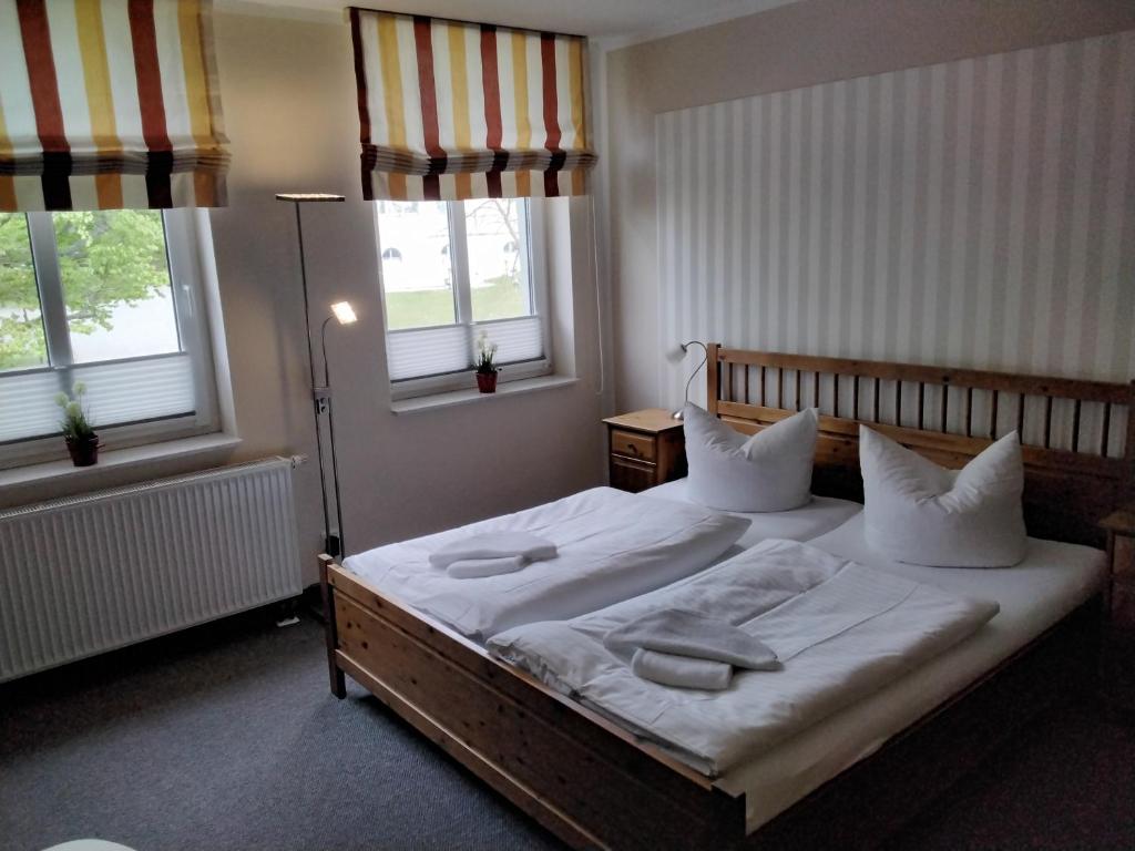 瓦伦Hotel am Weinbergschloss的一间卧室配有带白色床单和枕头的床。