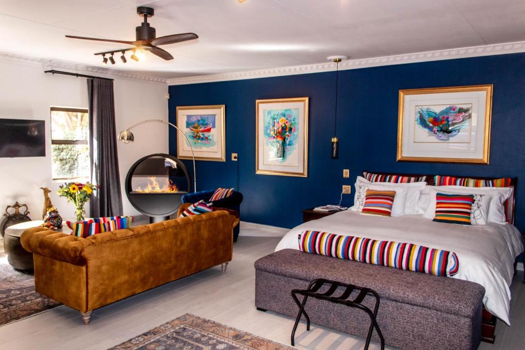 波罗瓜尼Forty 4 On Hoog的卧室拥有蓝色的墙壁,配有一张床和一张沙发