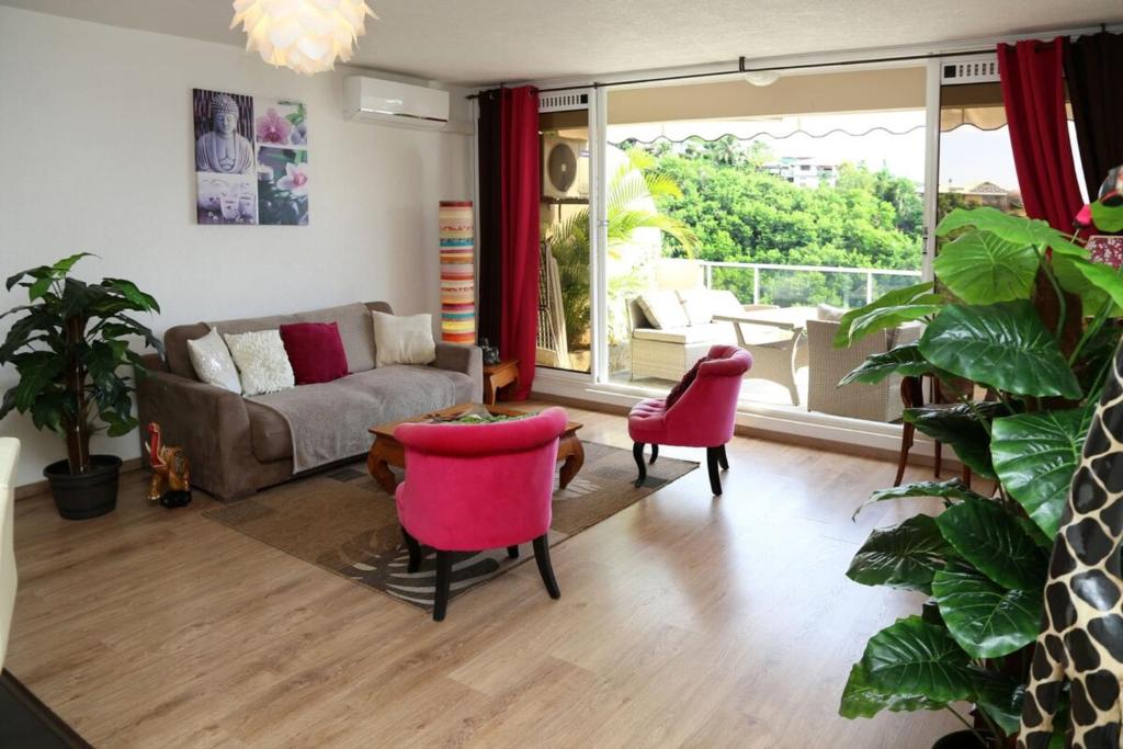 普纳奥亚Punauia Quiet apartment with sea view的客厅配有沙发和2把粉红色的椅子