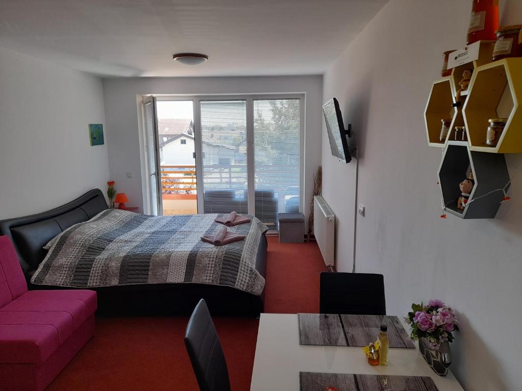 摩拉瓦托普利采Honey Apartment的一间卧室配有一张床和一张粉红色的沙发