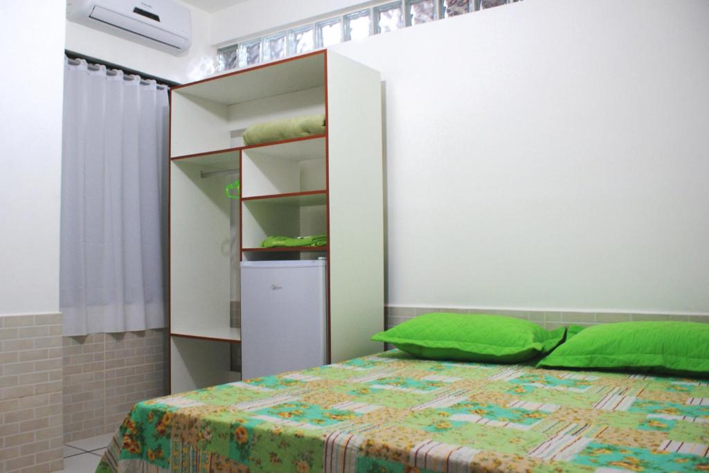 马卡埃Pousada Bem Brasil的一间卧室设有一张床和一个书架