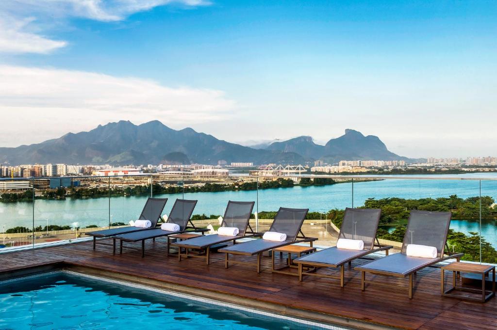 里约热内卢Lagune Barra Hotel的一组椅子坐在泳池旁的甲板上