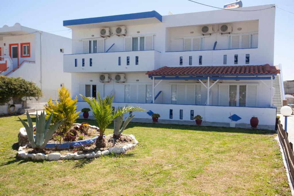 凯法洛斯Villa Bel Passo Apartments的一座白色的建筑,前面有棕榈树
